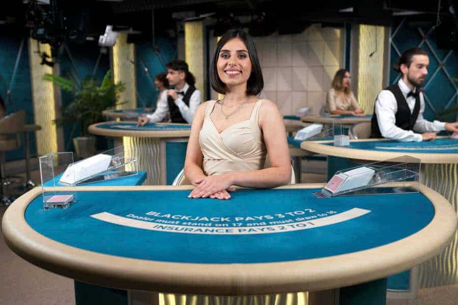 Blackjack dealer posing at blue table